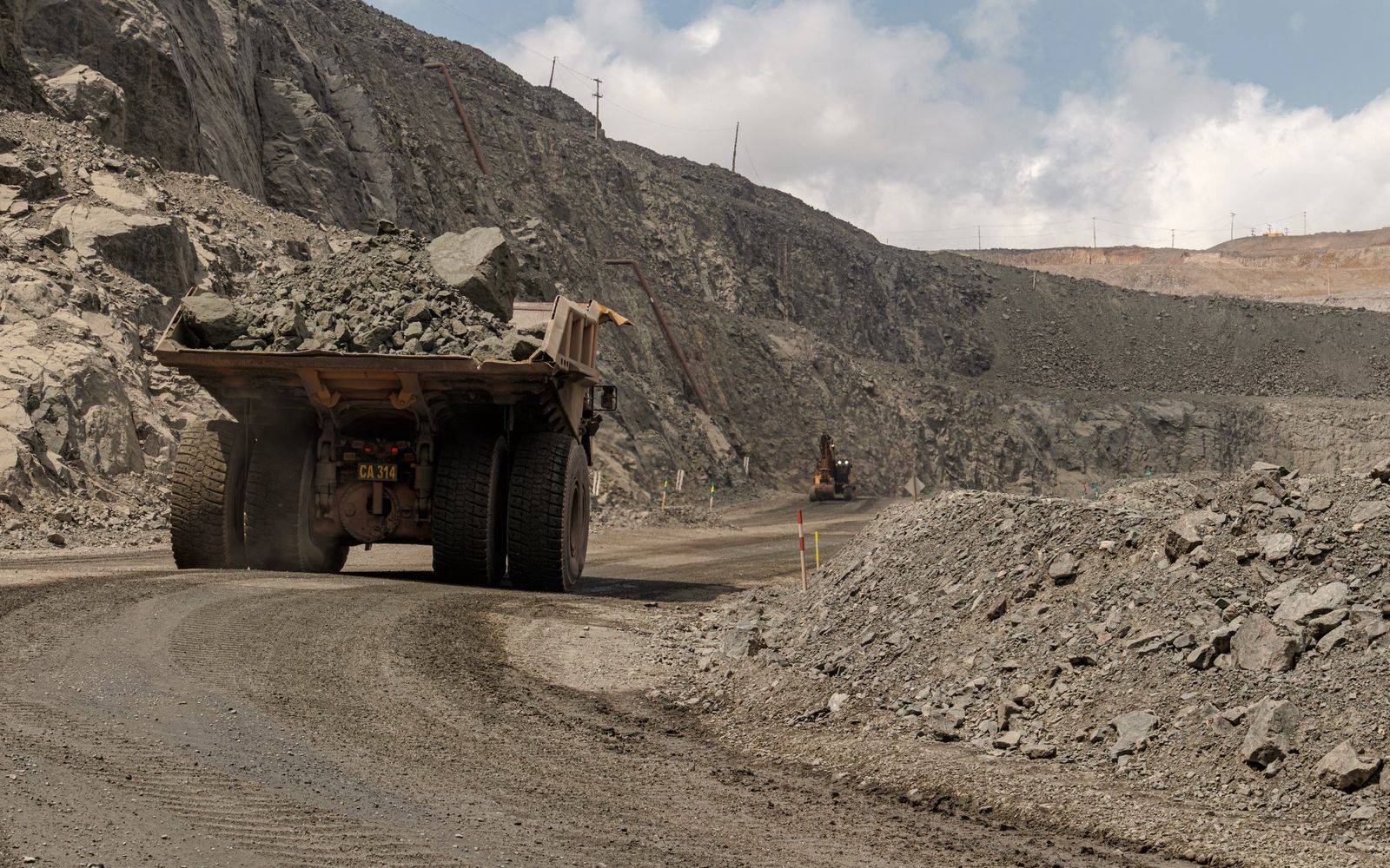A large haul truck carrying ore along a haul road in an open-pit mine.